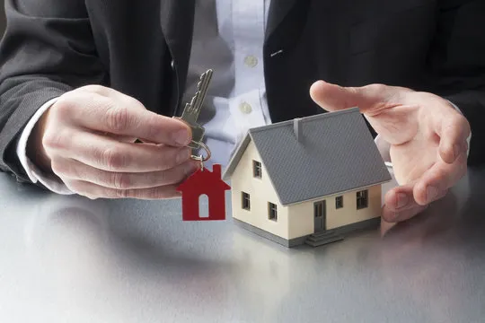 Property agent presenting a house and keys